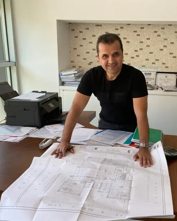 The founder of Vural Construction at his desk in the Alanya office, over a set of drawings